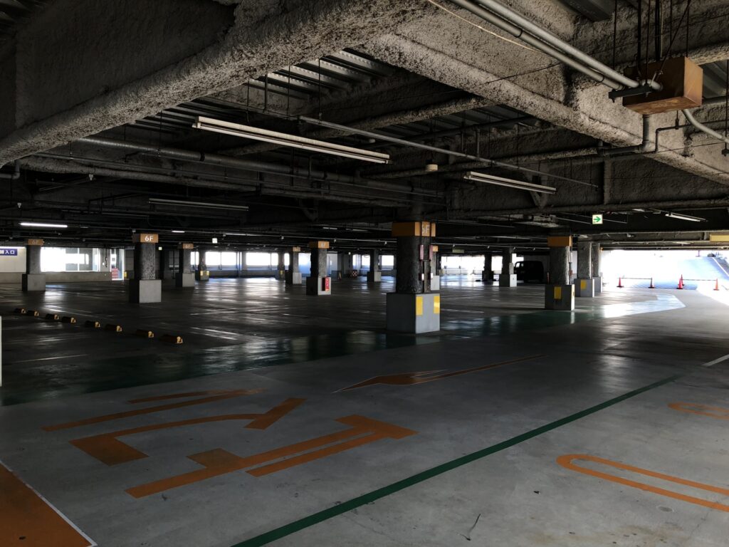 柱と駐車枠が並ぶ屋内の立体駐車場