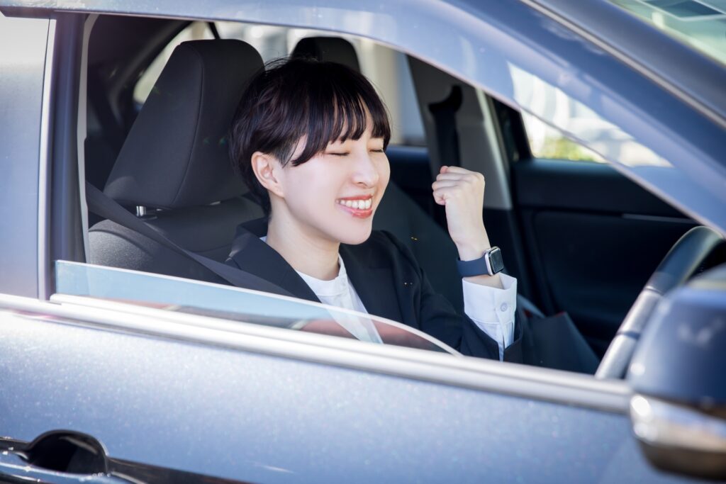 運転席で笑顔を見せる女性
