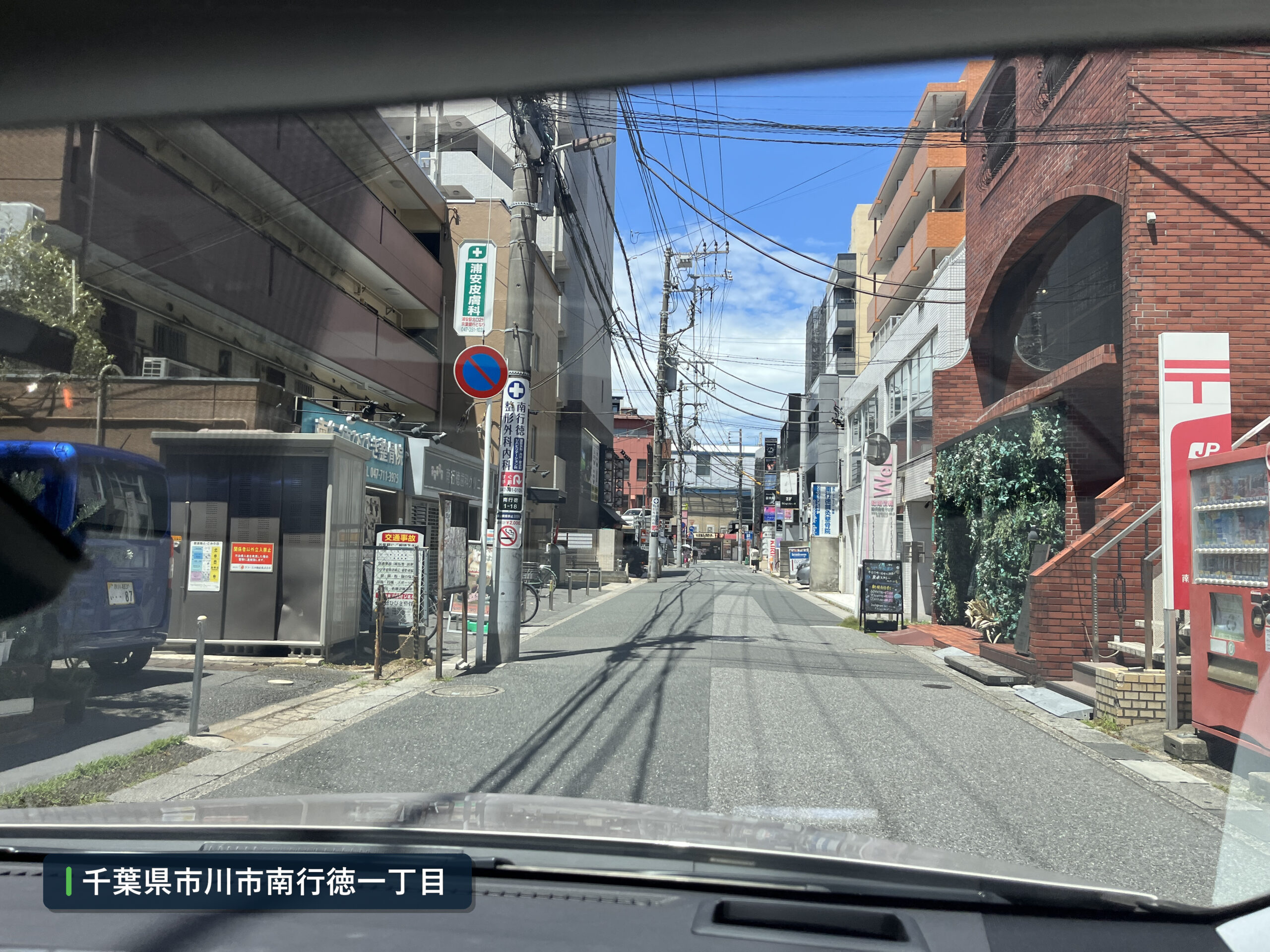 南行徳駅南口の店舗と停車車両がある生活道路