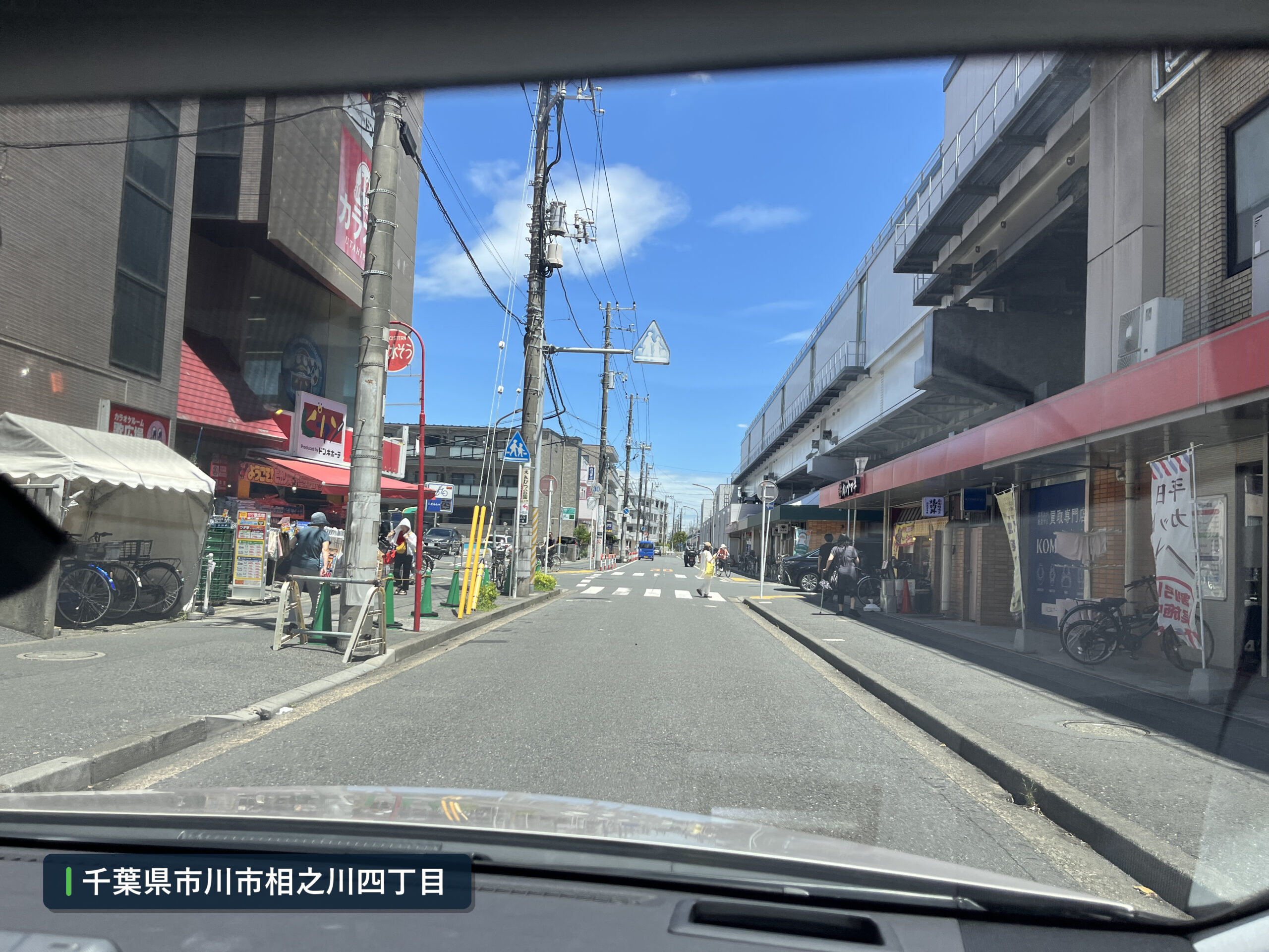 ピカソ南行徳駅前店前の歩行者と自転車が多い道路