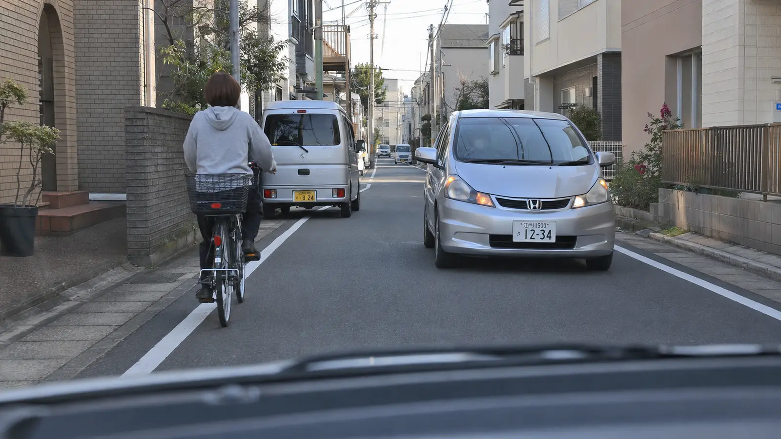 小岩・平井の細い生活道路で自転車の後ろを走る車を描いたイラスト