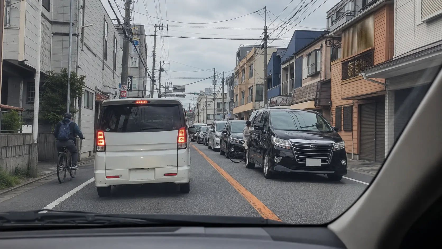 船橋市内の国道14号で自転車と対向車線の渋滞に注意して走る運転席からの視点