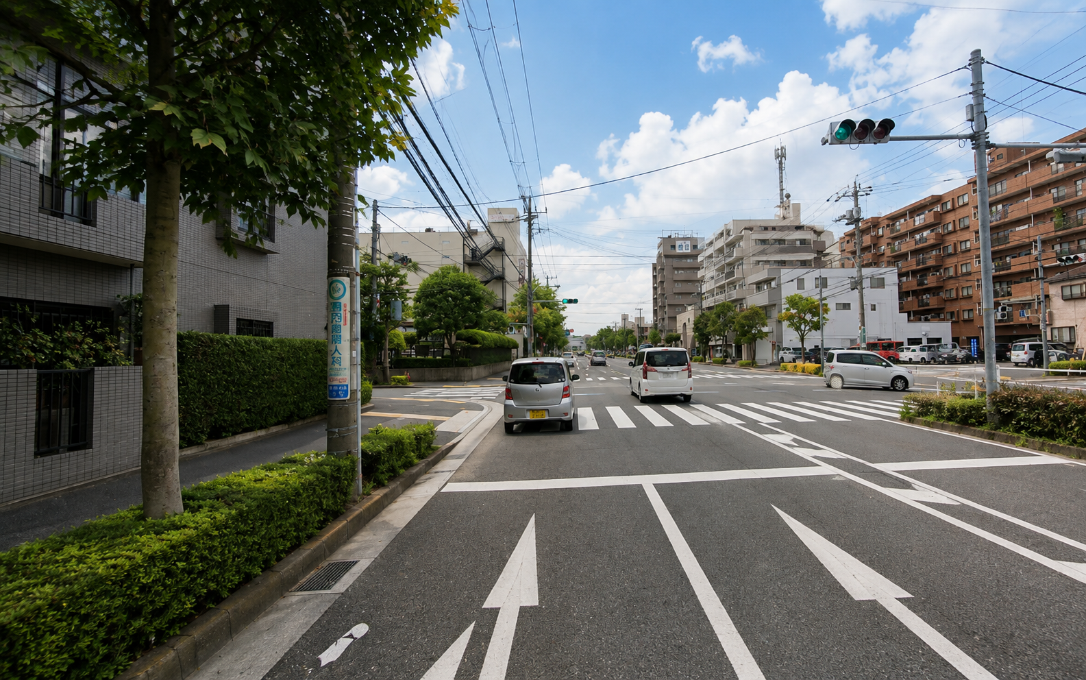 葛西中央通りの交差点で歩行者と自転車を確認しながら左折を練習する場面
