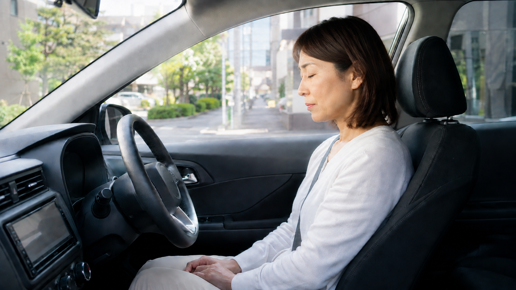 運転前に車内で深呼吸する女性