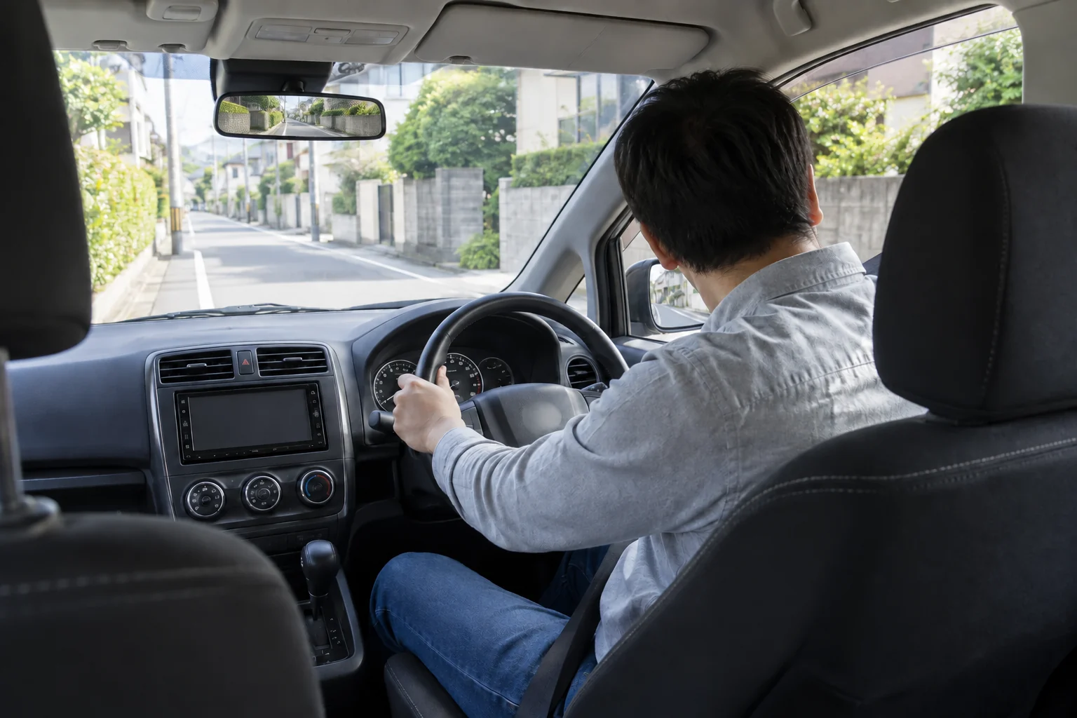 浦安市の住宅街で15年ぶりの運転を始める30代男性。ルームミラーには後方の道路が映る