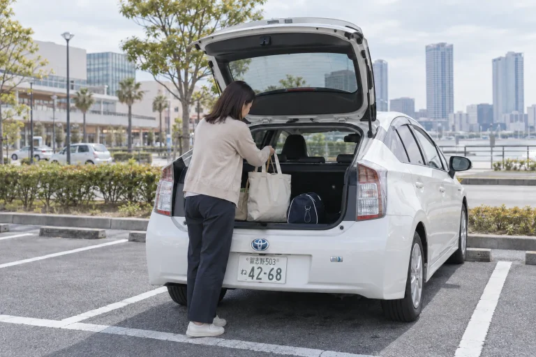 千葉市・海浜幕張の講習レポート：買い物袋と習い事の荷物を車に積む女性のイメージ