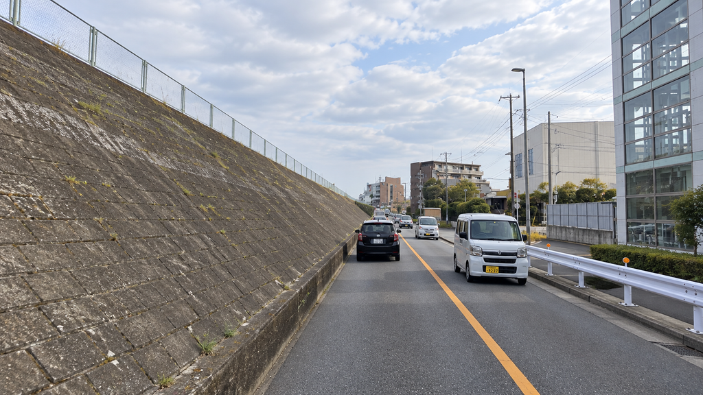 堤防と縁石に沿って対向車とすれ違う道路
